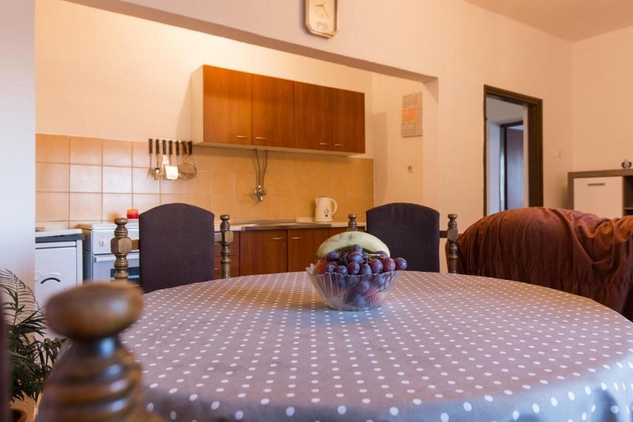 Jedálenský kút s okrúhlym obrusom a otvorenou kuchyňou