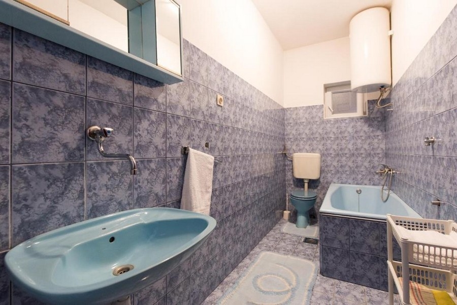 Kúpeľňa s modrým obkladom, vaňou a umývadlom