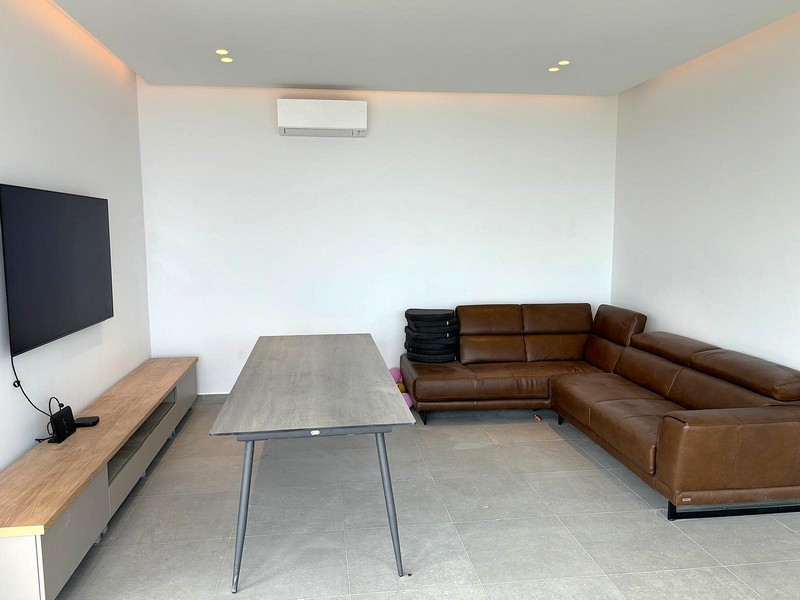 Obývacia izba s koženou pohovkou a nástennou TV