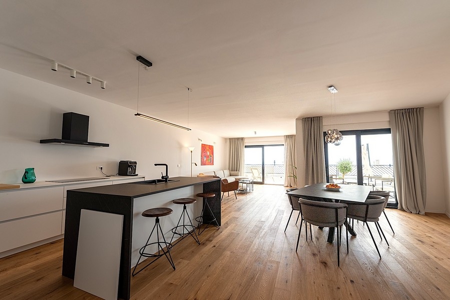 Moderná kuchyňa s ostrovčekom, jedálenským kútom a obývacou časťou v pozadí