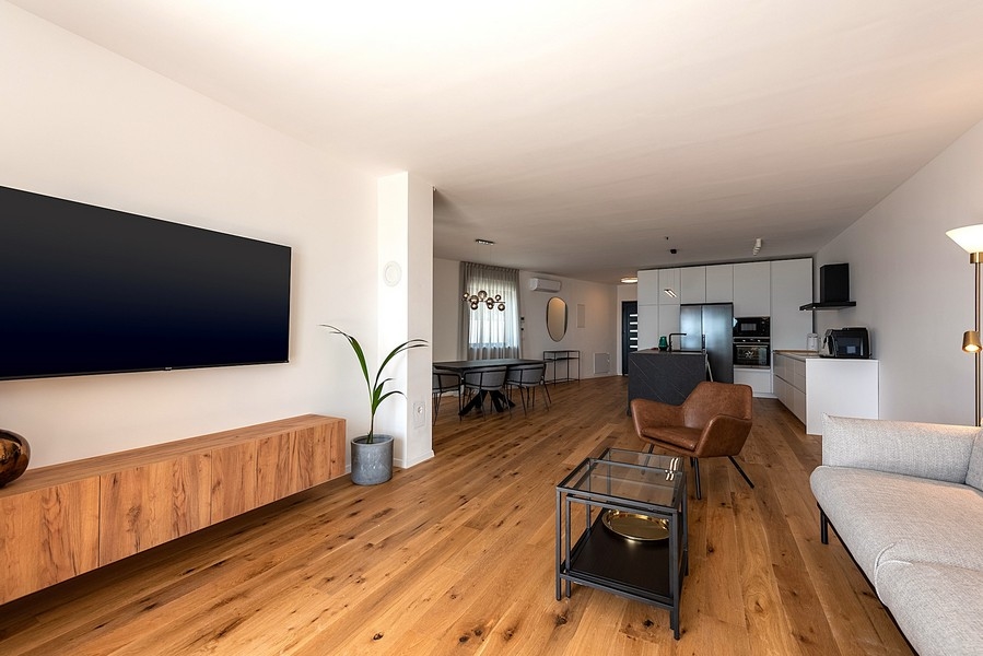 Otvorený obývací priestor s kuchyňou, jedálenským kútom a svetlým nábytkom