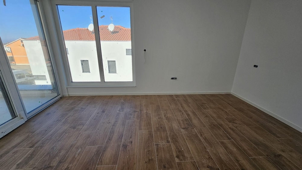 Spálňa s oknami od podlahy až po strop a drevenými podlahami