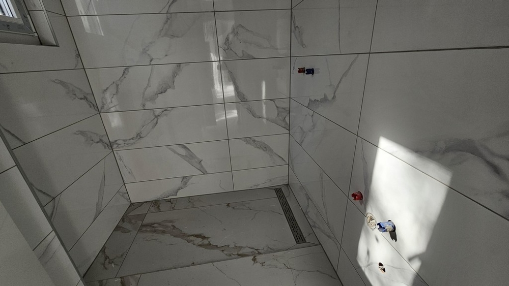 Moderná dláždená kúpeľňa so sprchovacím kútom