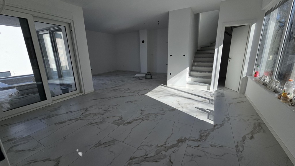 Svetlý obývací priestor s mramorovými podlahami a schodmi