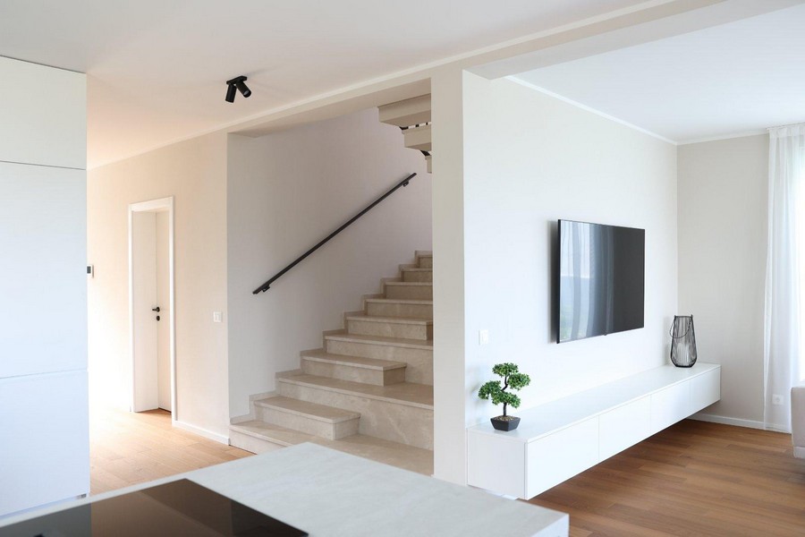 Moderná svetlá kuchyňa so závesnými policami a vstavanými spotrebičmi