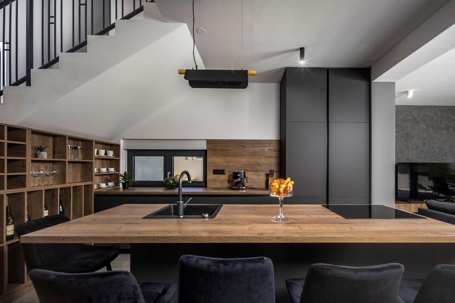 Moderná kuchyňa s dreveným pultom a čiernymi prvkami