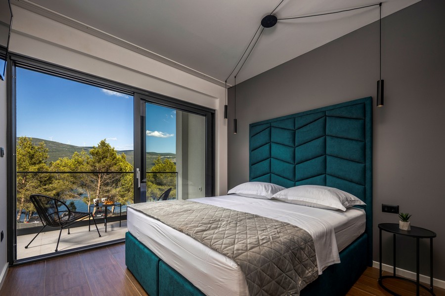 Spálňa s veľkou posteľou a panoramatickým oknom