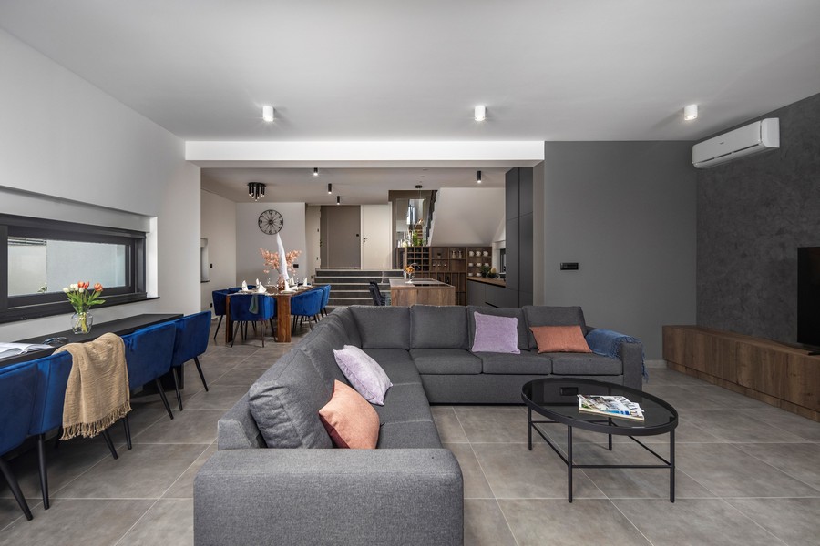 Moderná obývacia izba so sivou pohovkou a jedálenským kútom