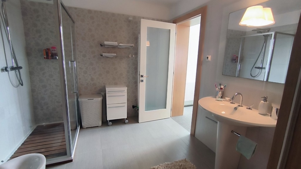 Moderná kúpeľňa s veľkým sprchovacím kútom a zrkadlom