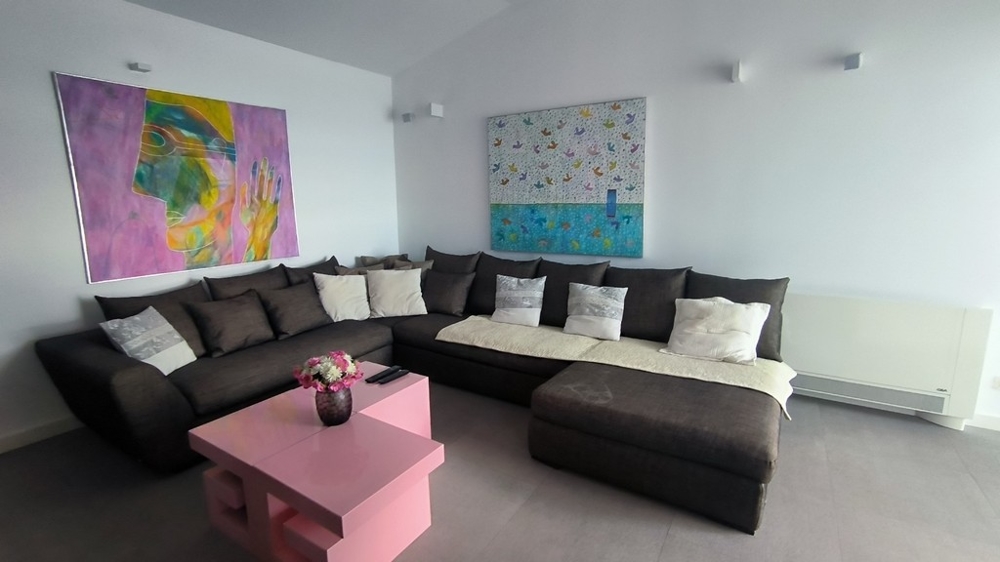 Moderne zariadená obývacia izba s veľkou rohovou pohovkou