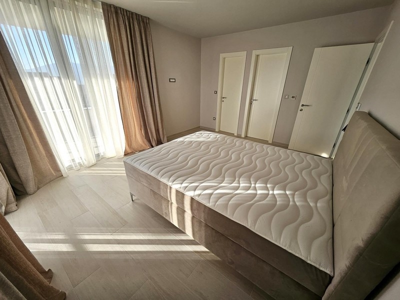 Priestranná spálňa s veľkými oknami a manželskou posteľou