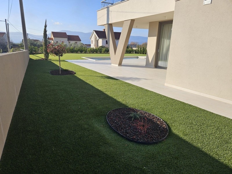 Moderná záhrada s trávnikom a terasou vily na Krku