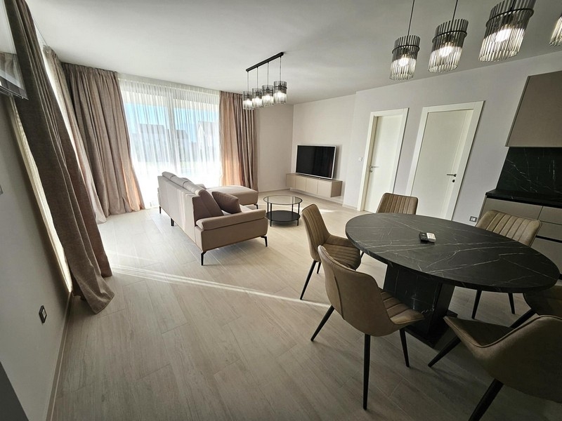 Svetlá obývacia izba so sedacou súpravou a TV, veľké okná