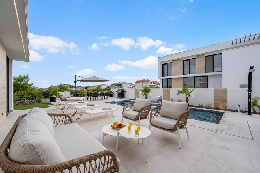 Vonkajší priestor s bazénom, ležadlami a grilom