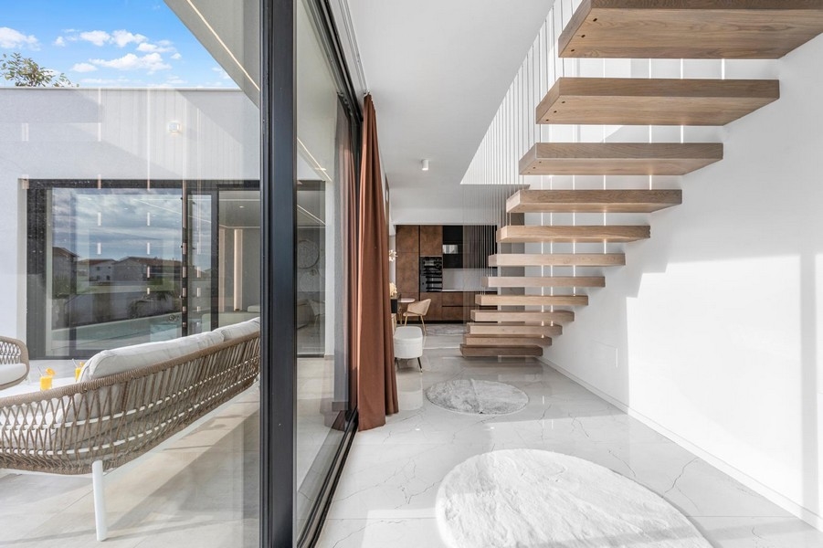 Svetlá galéria s plávajúcim schodiskom a veľkými oknami