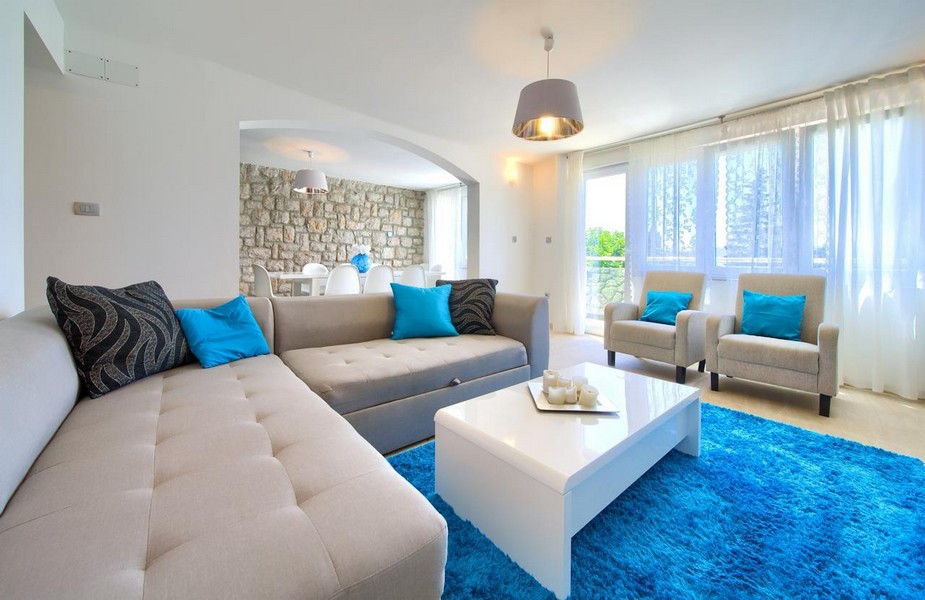 Moderná obývacia izba s veľkou pohovkou a výhľadom na more