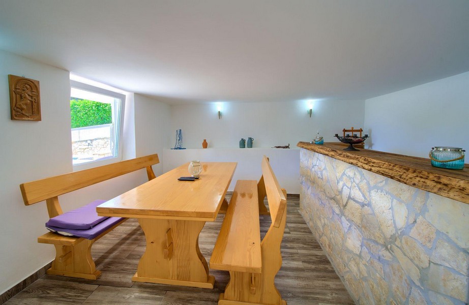 Útulná hobby miestnosť s dreveným stolom a kamenným barom