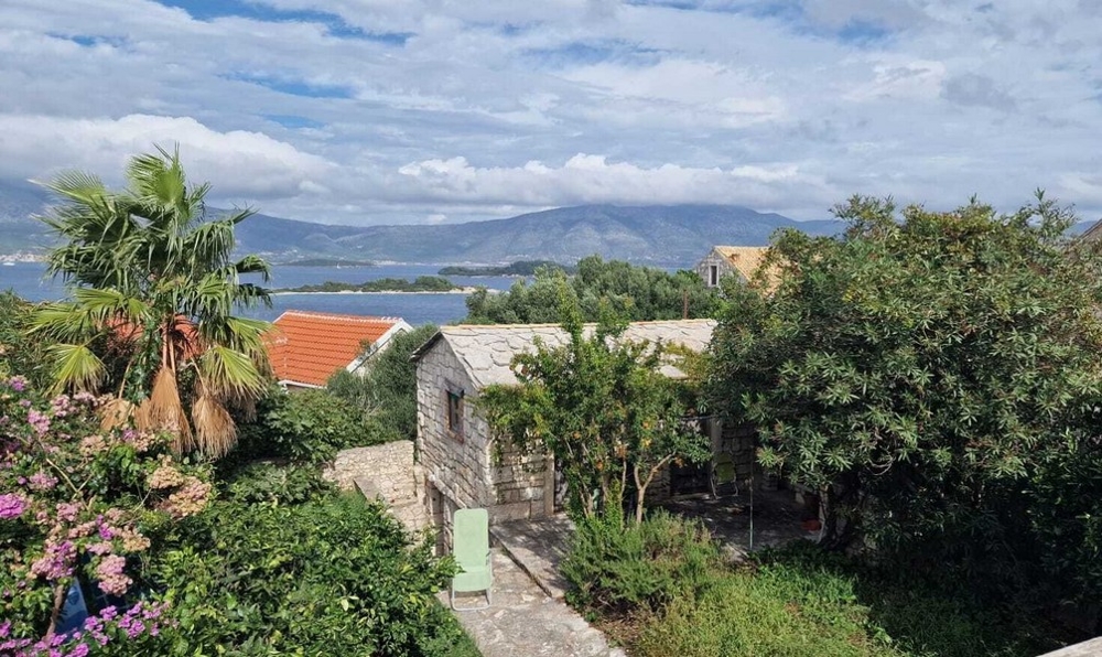 Výhľad na more a záhrada s domom z prírodného kameňa