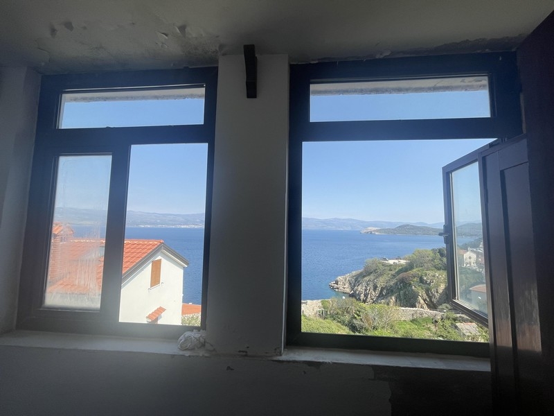 Pohľad cez okno na more a pobrežie