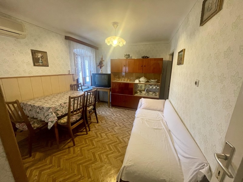 Obývacia časť s jedálenským stolom, pohovkou a vitrínou