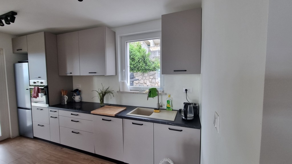 Moderne zariadená kuchyňa s oknom a výhľadom do záhrady