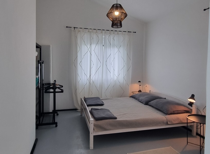 Spálňa s manželskou posteľou a vešiakom