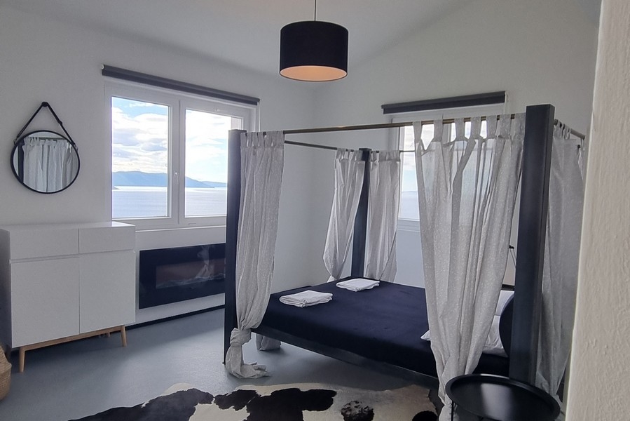 Spálňa s posteľou s baldachýnom a výhľadom na more