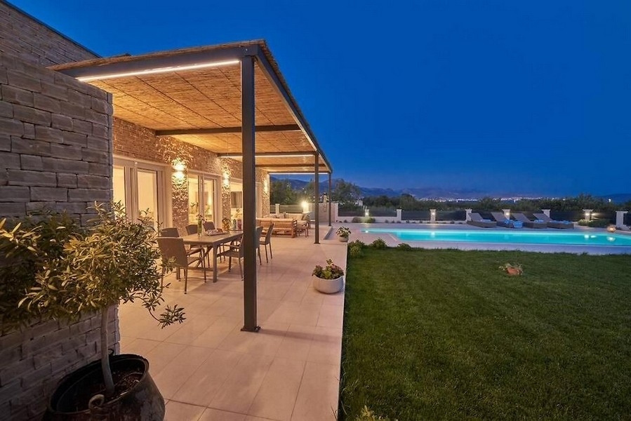 Krytá terasa so záhradou a bazénom v noci