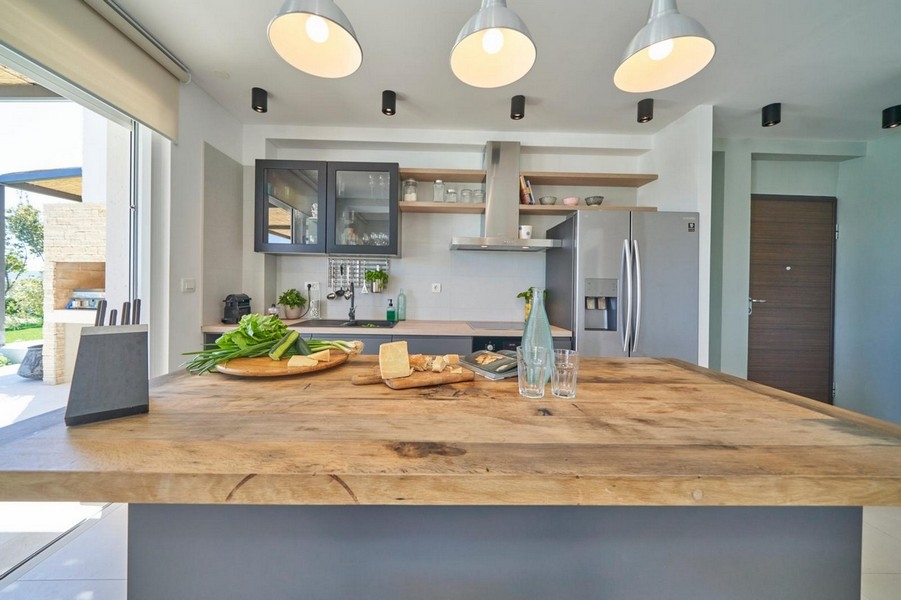 Kuchynský ostrovček s drevenou pracovnou doskou a lampami