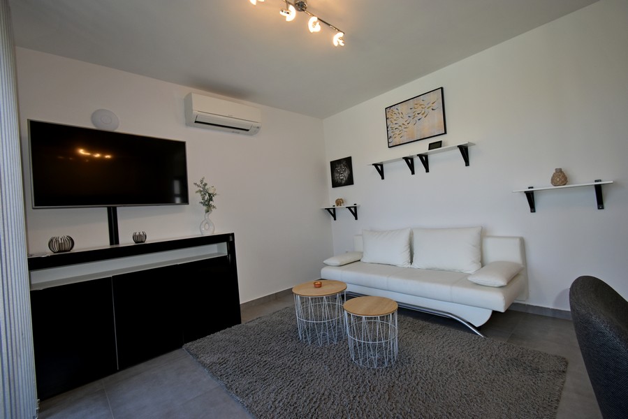 Obývacia izba s pohovkou, TV a klimatizáciou