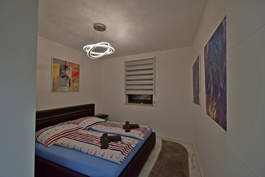 Spálňa s manželskou posteľou a nástennými maľbami