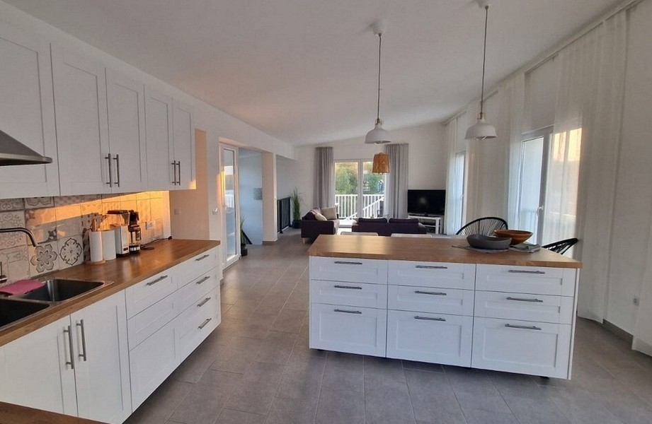 Svetlá kuchyňa s ostrovčekom na varenie a obývacím priestorom