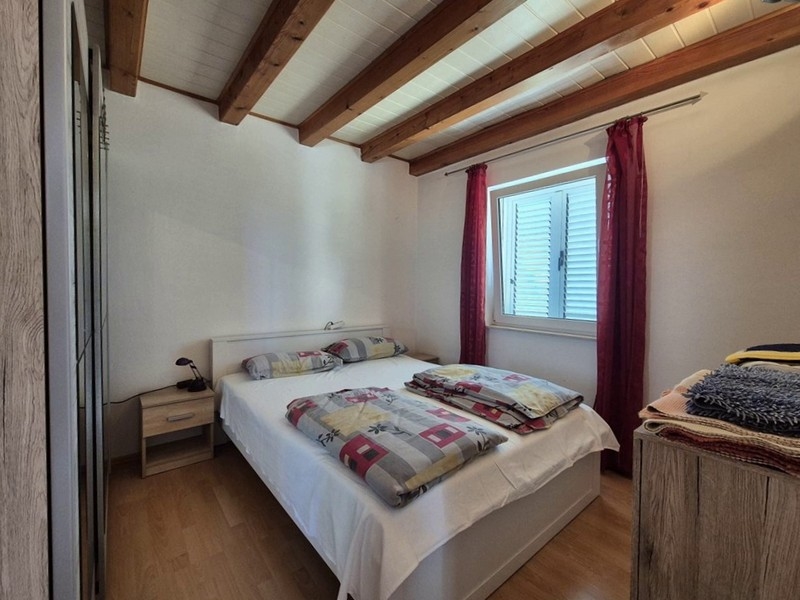 Spálňa s manželskou posteľou a trámovým stropom