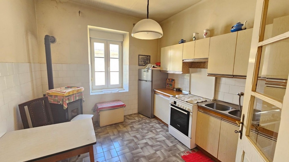 Jednoduchá kuchyňa s oknom a rúrou