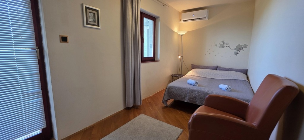 Malá spálňa s manželskou posteľou a kreslom