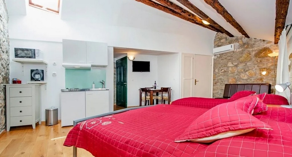 Štúdio s kamennou stenou, manželskou posteľou a kuchynkou