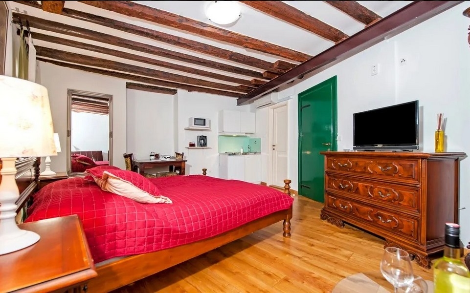 Útulné štúdio so zeleným vchodom a TV