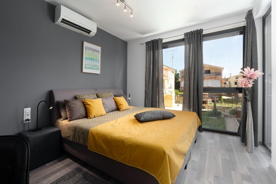 Spálňa s manželskou posteľou a žltou posteľnou bielizňou