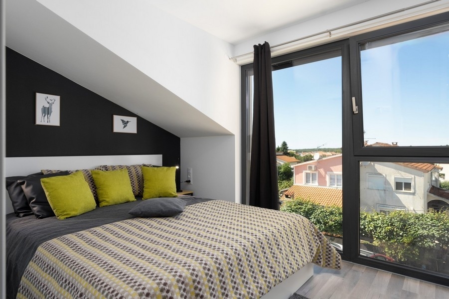 Podkrovná spálňa s veľkým oknom a výhľadom