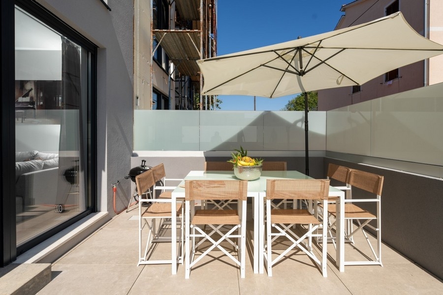 Terasa s jedálenským stolom a slnečníkom