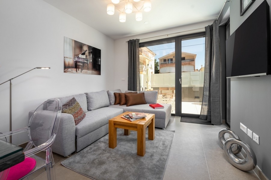 Obývacia izba s rohovou sedačkou a vstupom na terasu