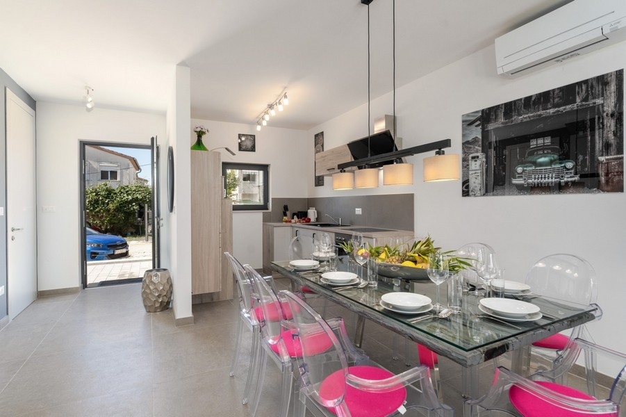 Jedálenský kút so skleneným jedálenským stolom a modernou kuchyňou