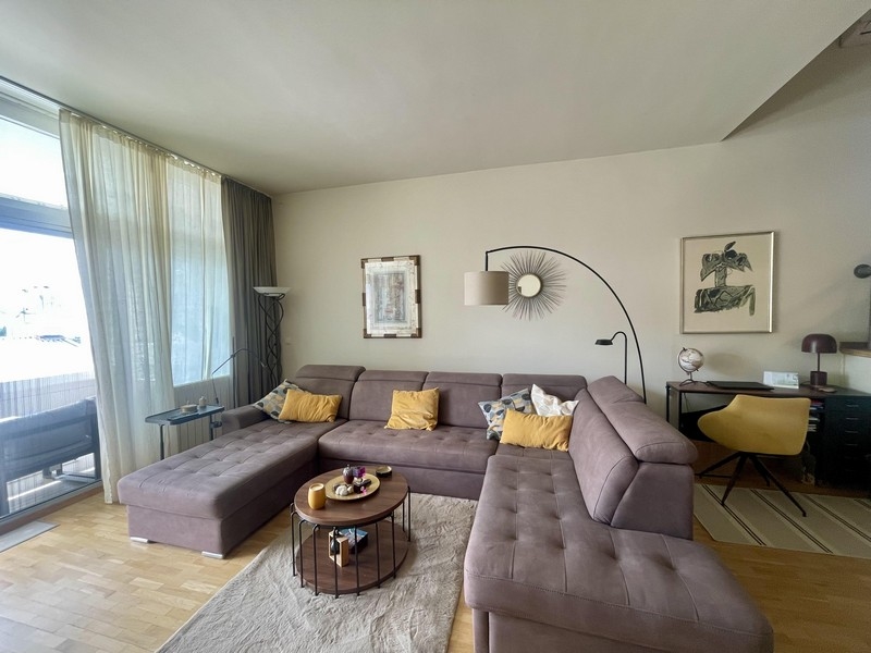 Moderná obývacia izba s rohovou pohovkou a vstupom na balkón