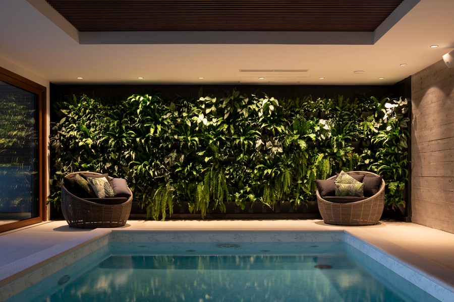 Vnútorný bazén so stenou zo zelených rastlín a posedením
