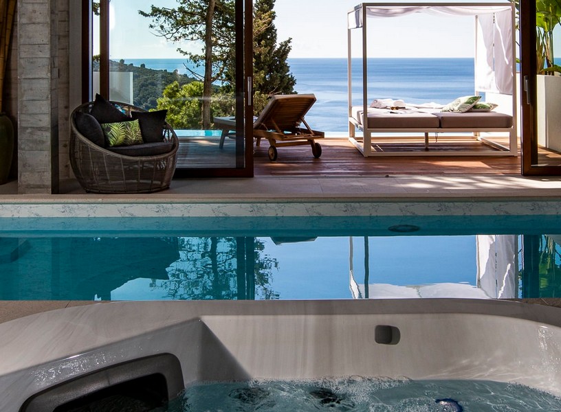 Vnútorný bazén s vírivkou s výhľadom na slnečnú terasu s výhľadom na more