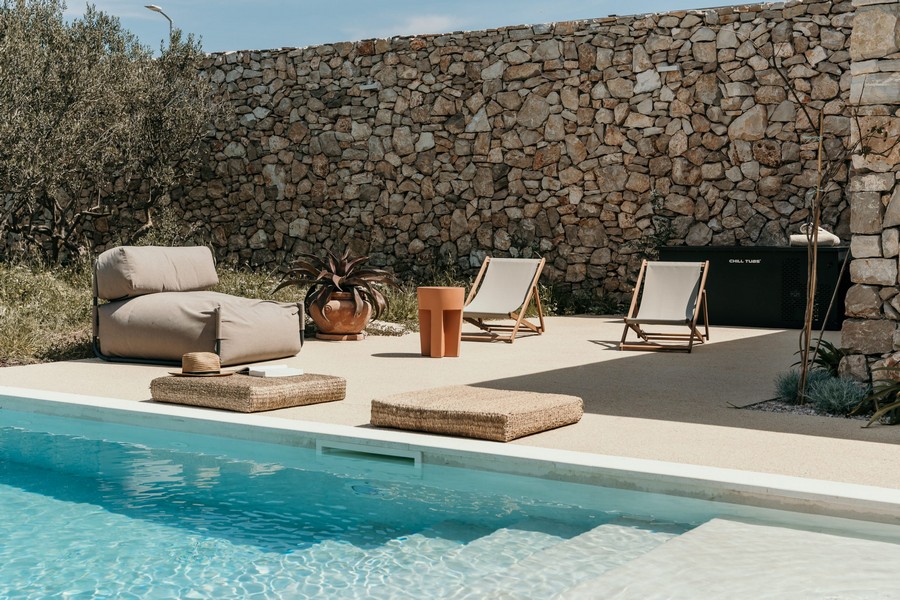 Bazén s ležadlami a stenou z prírodného kameňa