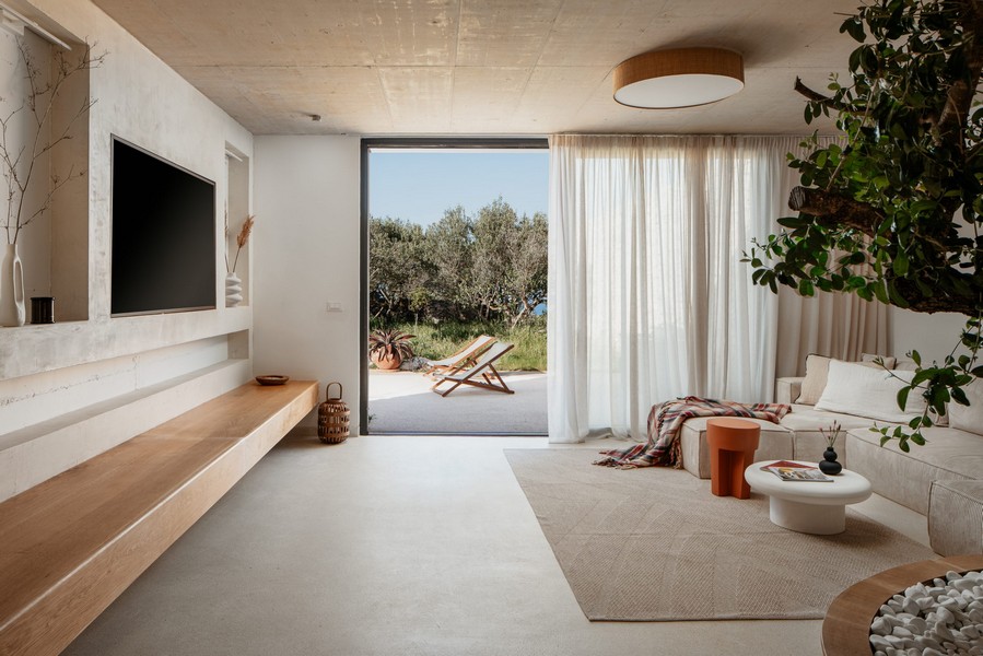 Obývacia izba s oknami od podlahy až po strop a prístupom do záhrady