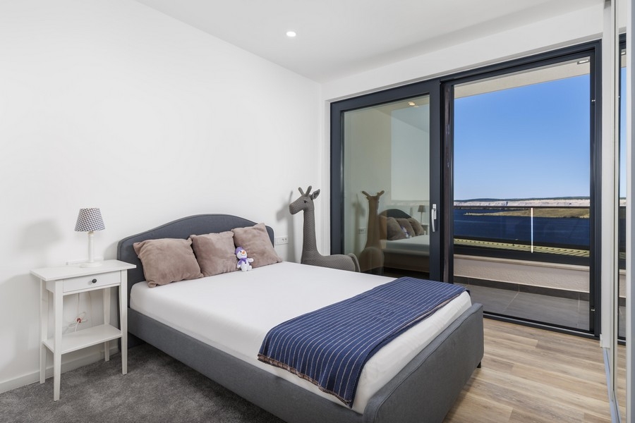 Svetlá spálňa s prístupom na balkón a výhľadom na more