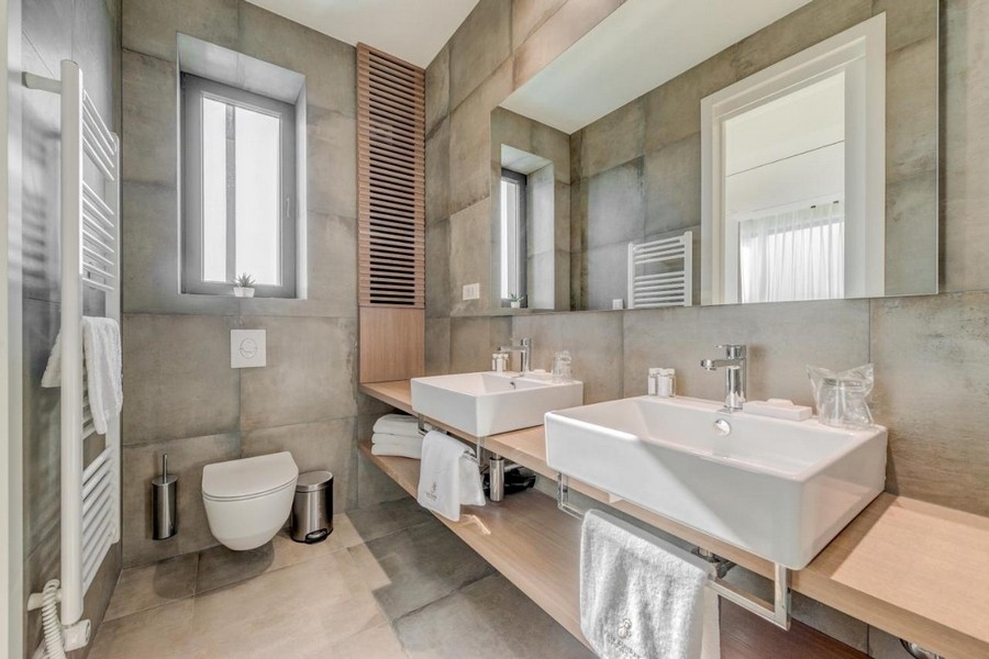 Moderná kúpeľňa s dvojitým umývadlom a oknom