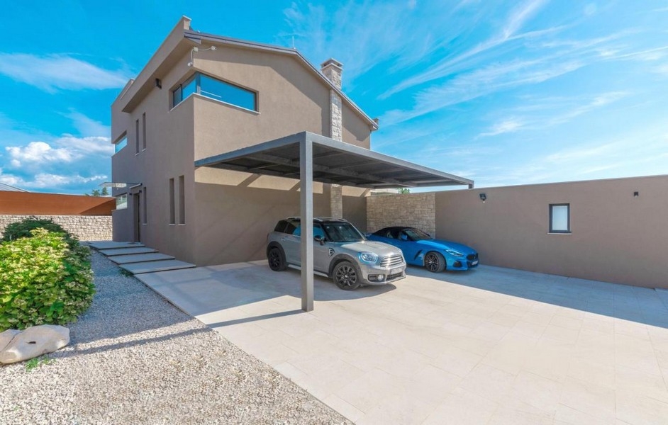 Krytý prístrešok na auto s dvomi autami pred vilou